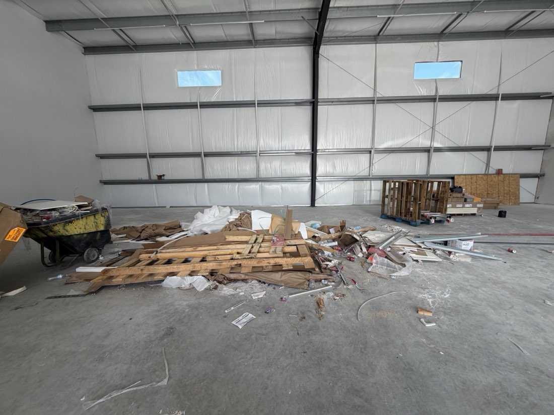 Warehouse floor covered in construction debris before junk removal
